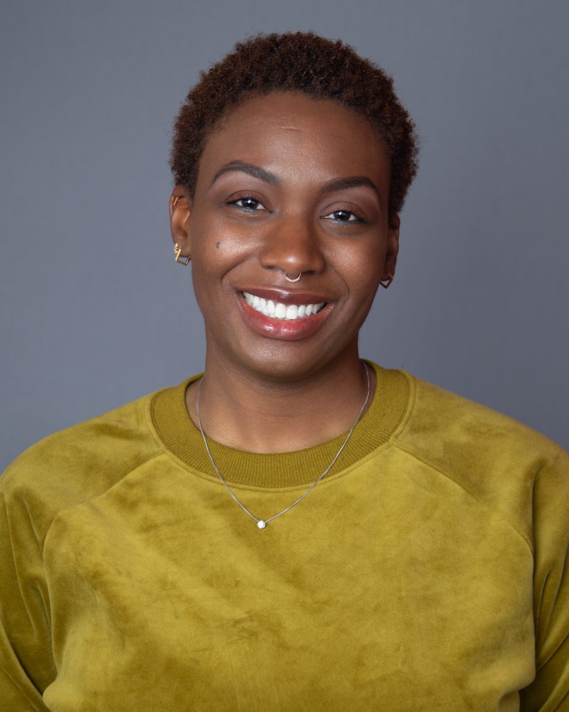 Varsey Laurelle headshot with green shirt and smile