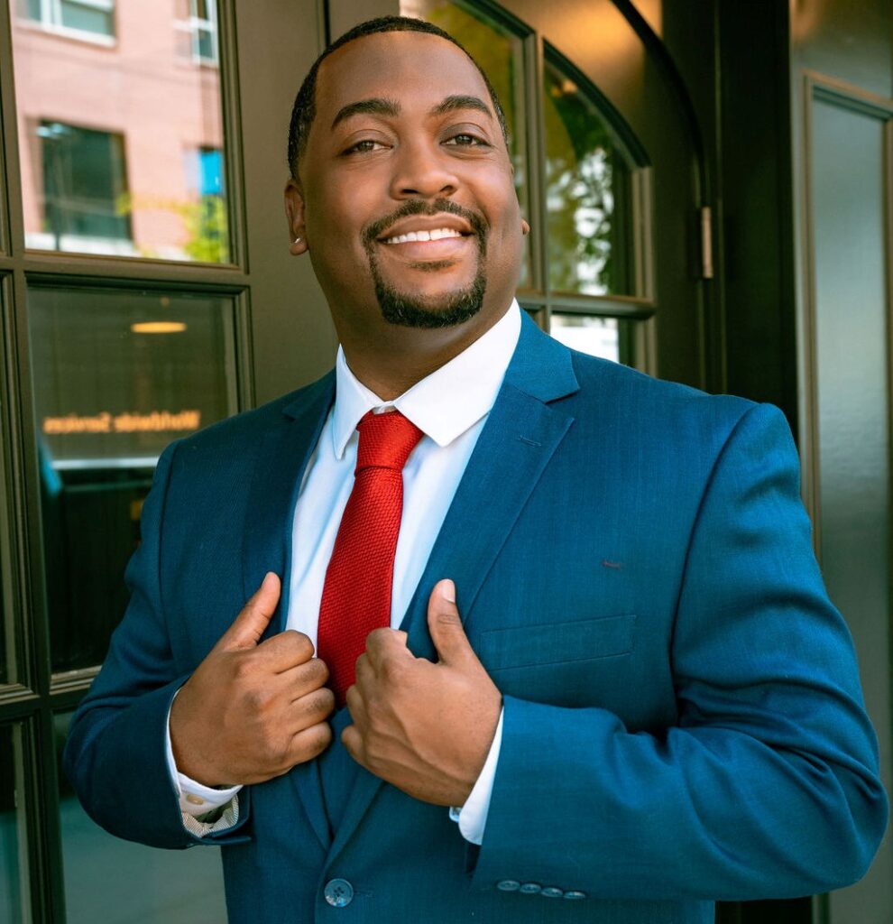 Craig M. Chavis Jr. headshot in blue suit with red tie