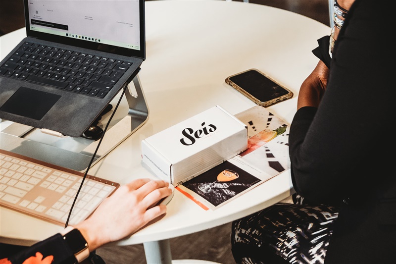 Products and laptop on desk between coworkers